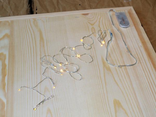 Anleitung für Lichtdekoration mit Sternzeichen: Lichterkette anbringen Lichterkette auf den Bilderrahmen fixeren in Form von dem Sternzeichen